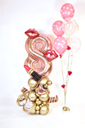 Decorative balloon sculpture with gold and pink balloons on a white background