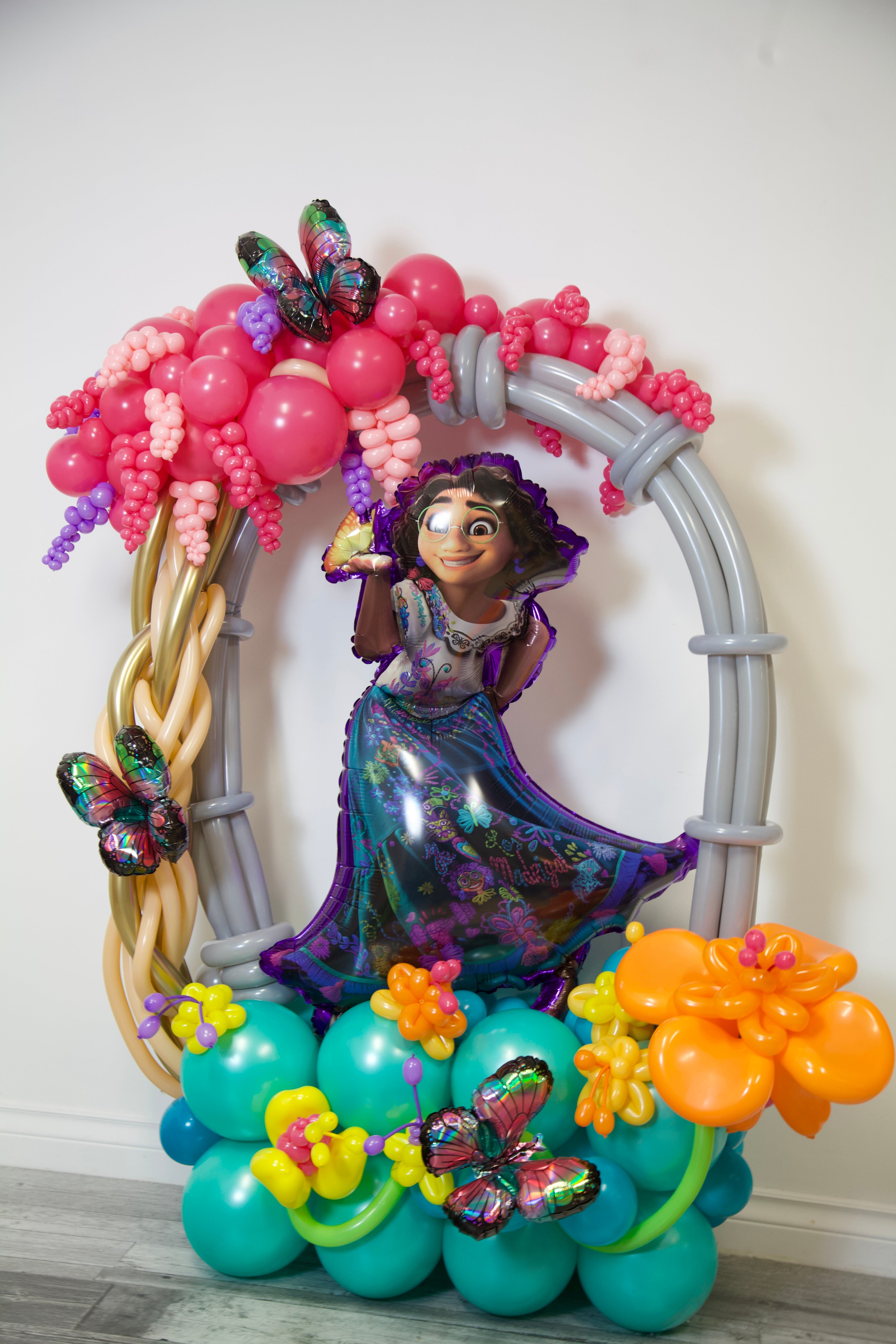 Balloon arch with decorative elements including a character figure and colorful balloons.