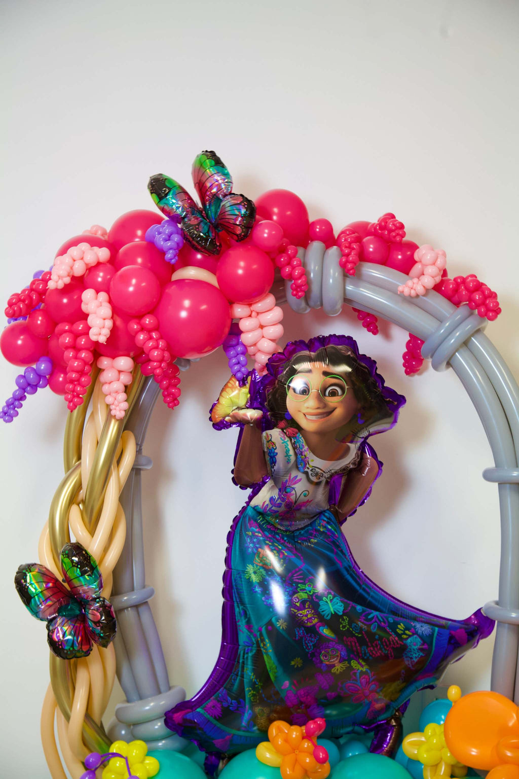 Encanto Birthday Balloon Display with character balloon, tropical flowers, butterfly accents, and colourful kids party decor