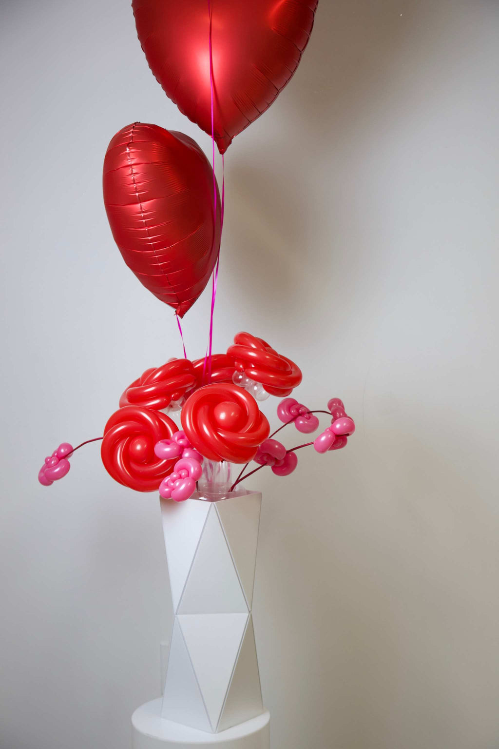 Romantic rose balloon arrangement with heart balloons in an elegant origami vase