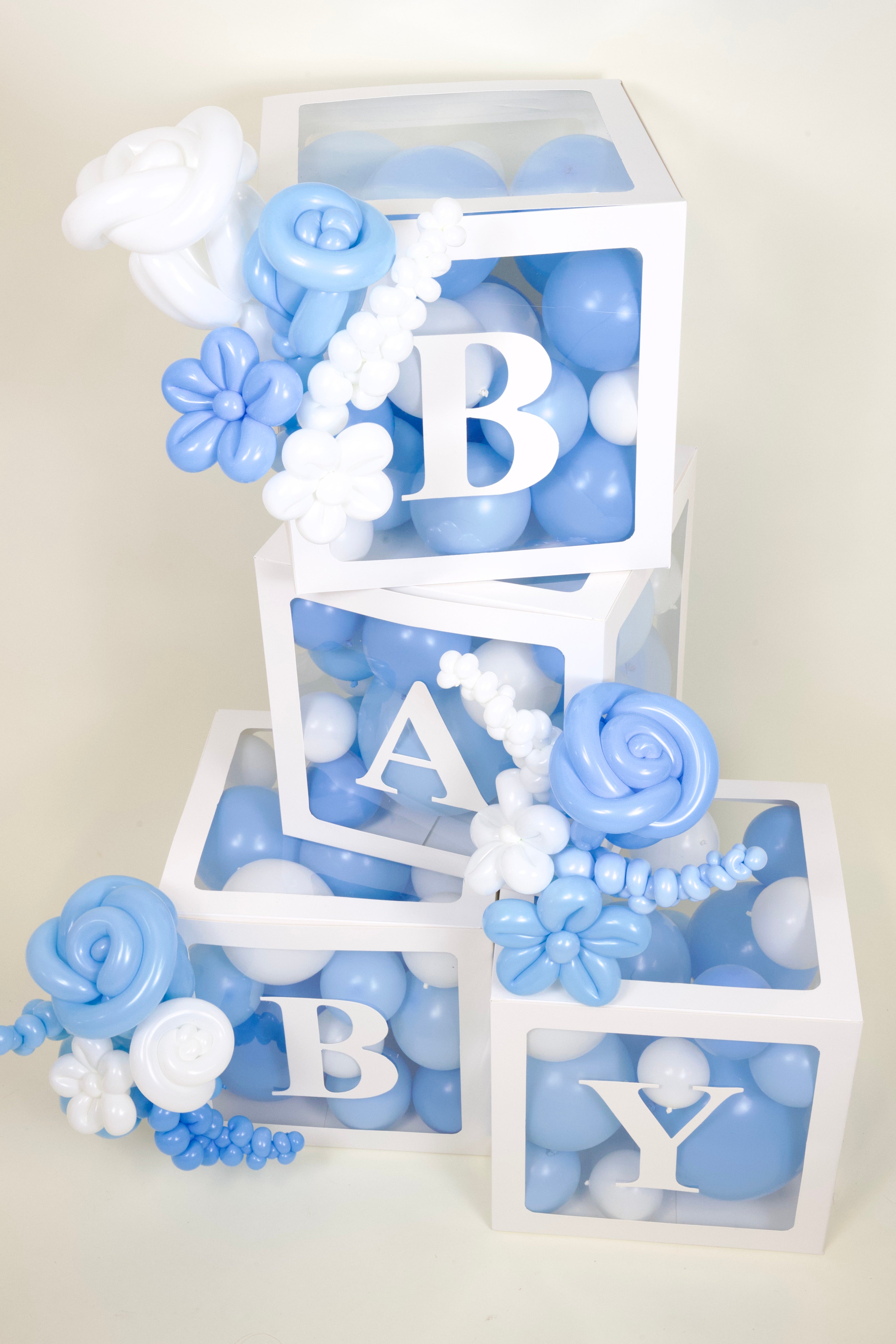 Decorative baby blocks with blue and white flowers and letters spelling 'BABY'.