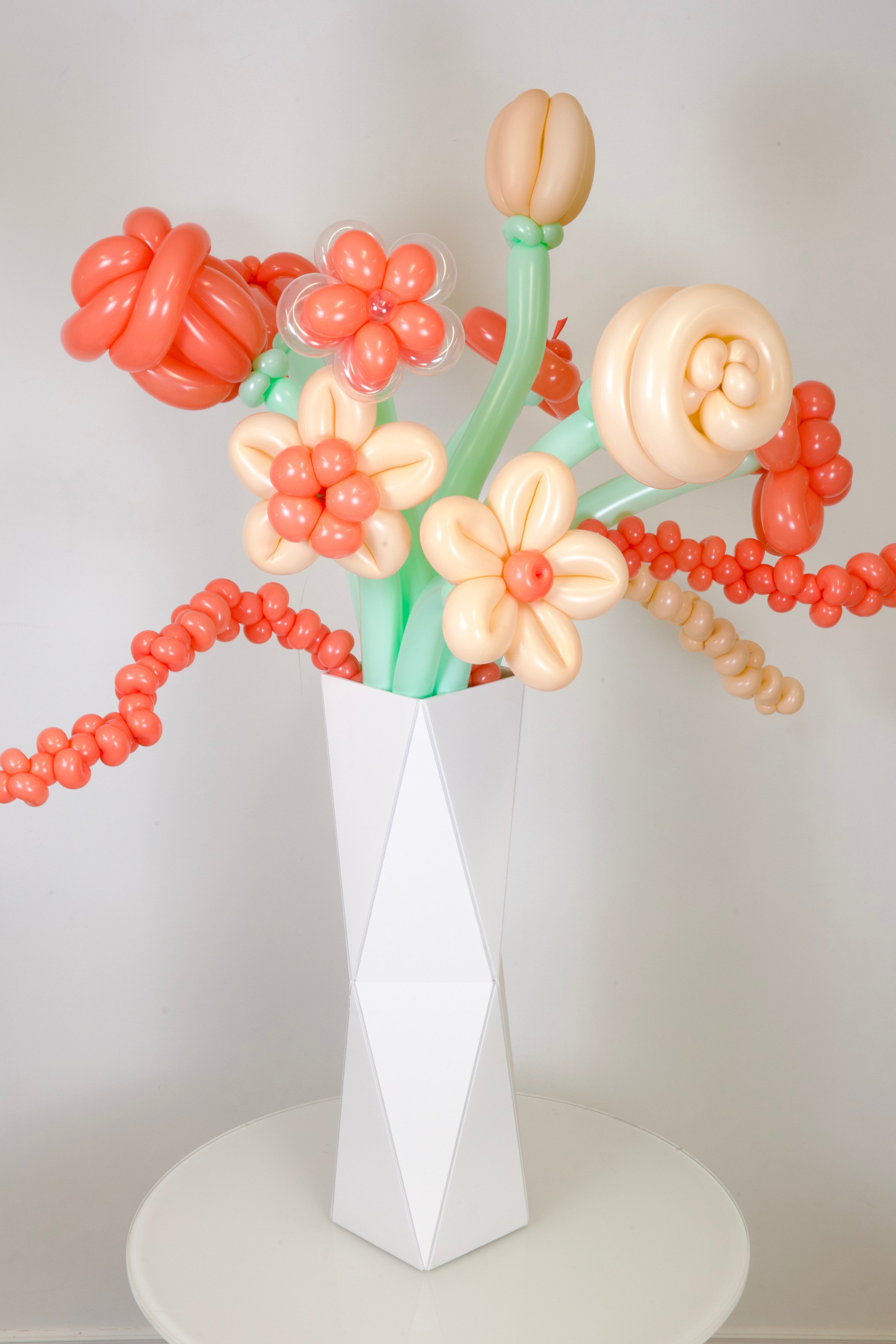 Balloon flower bouquet in a white vase on a light gray background
