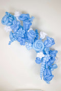 Baby shower balloon box display with blue white balloons, floral accents, and photo-ready event styling