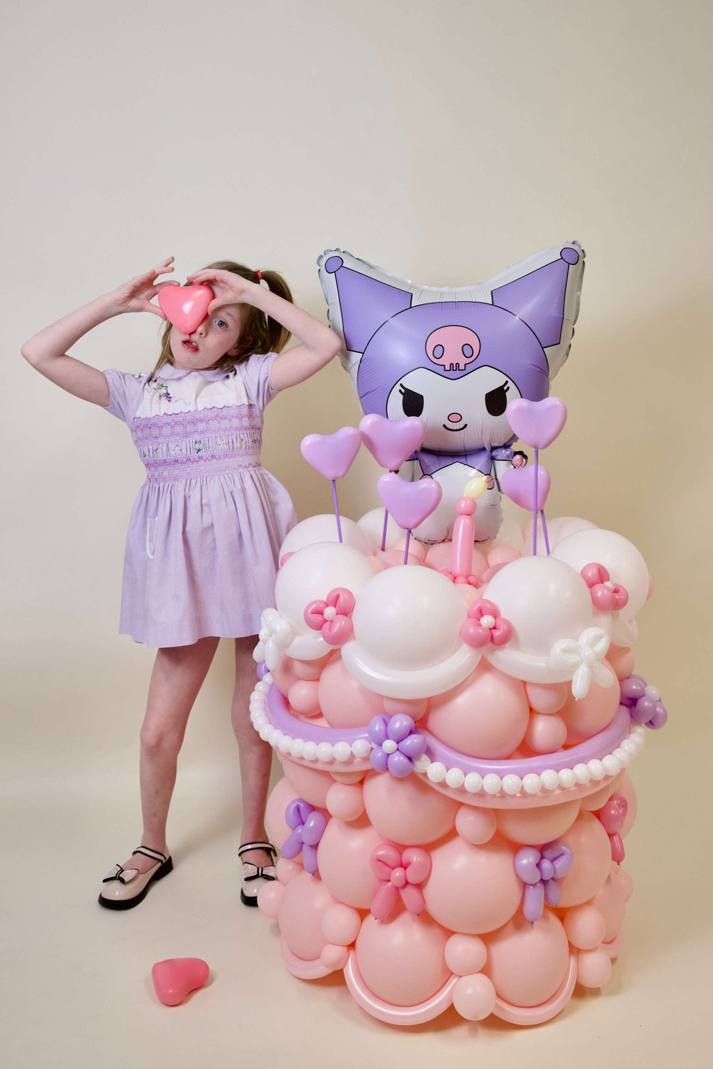 Kuromi birthday balloons with pastel pink and lavender balloon display, floral details, heart accents, and girls party decor
