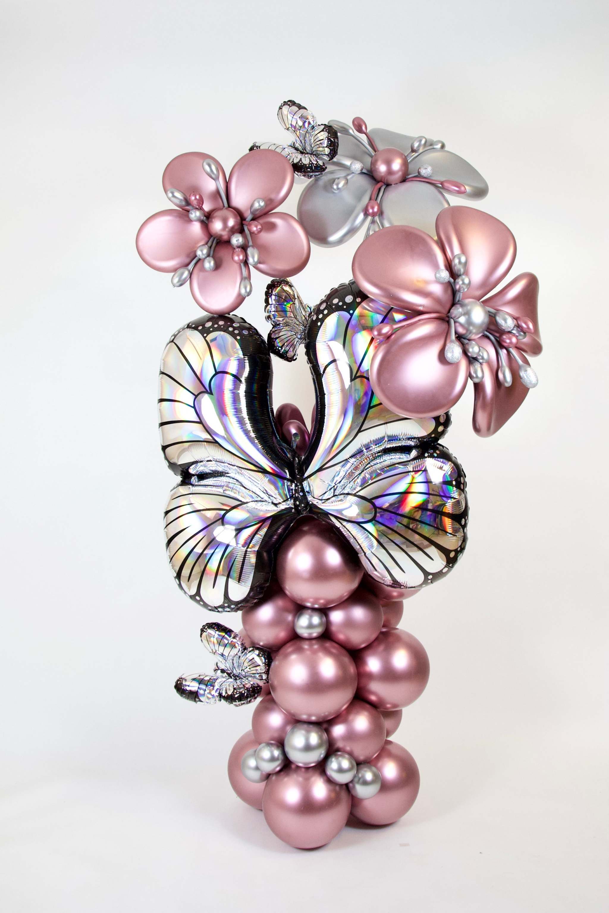 Butterfly Balloon Column with rose gold balloons, iridescent butterfly accents, oversized balloon flowers, and elegant event decor