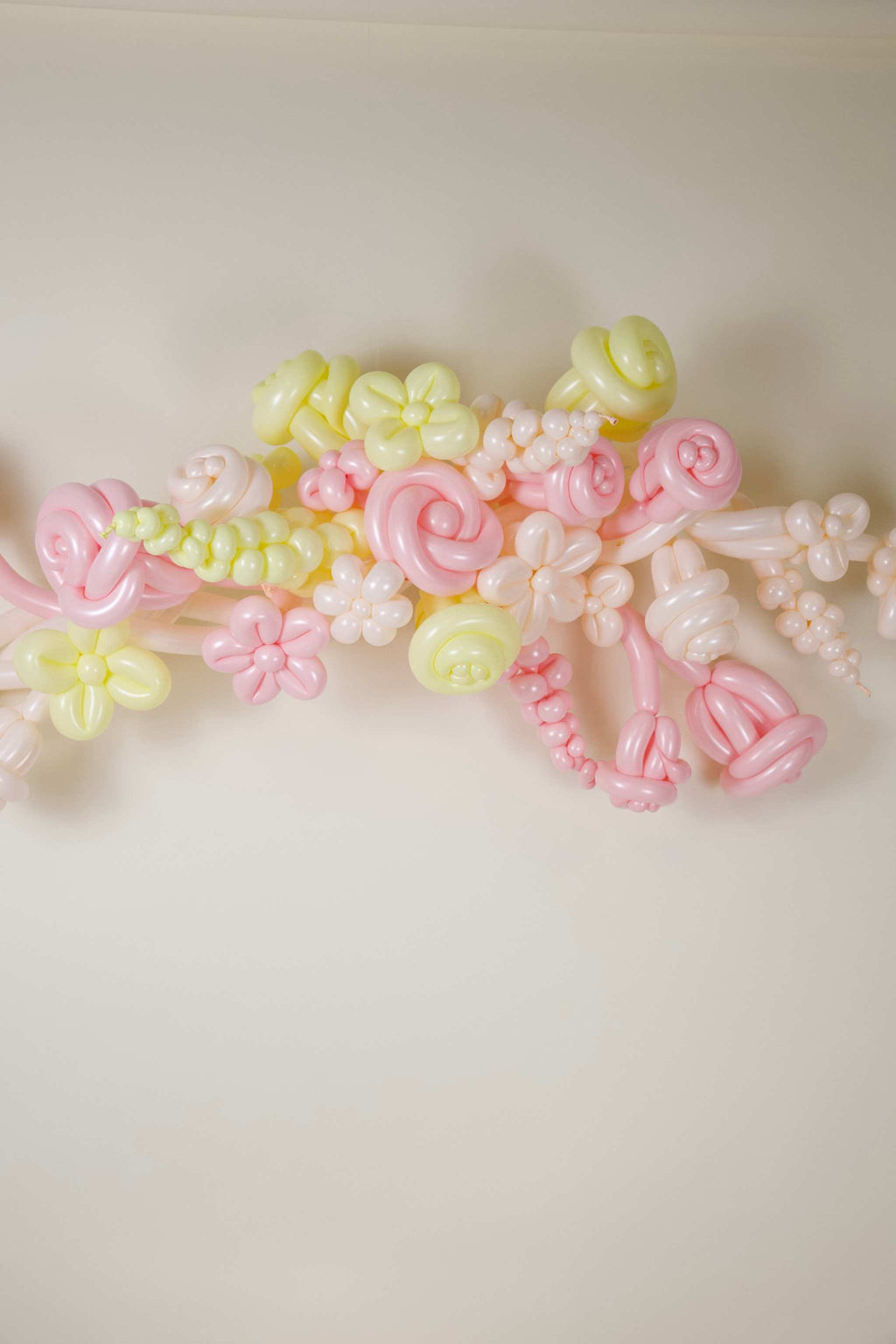 Pastel baby shower balloon box display with BABY letters, blush pink balloons, buttercream accents, and soft floral balloon details