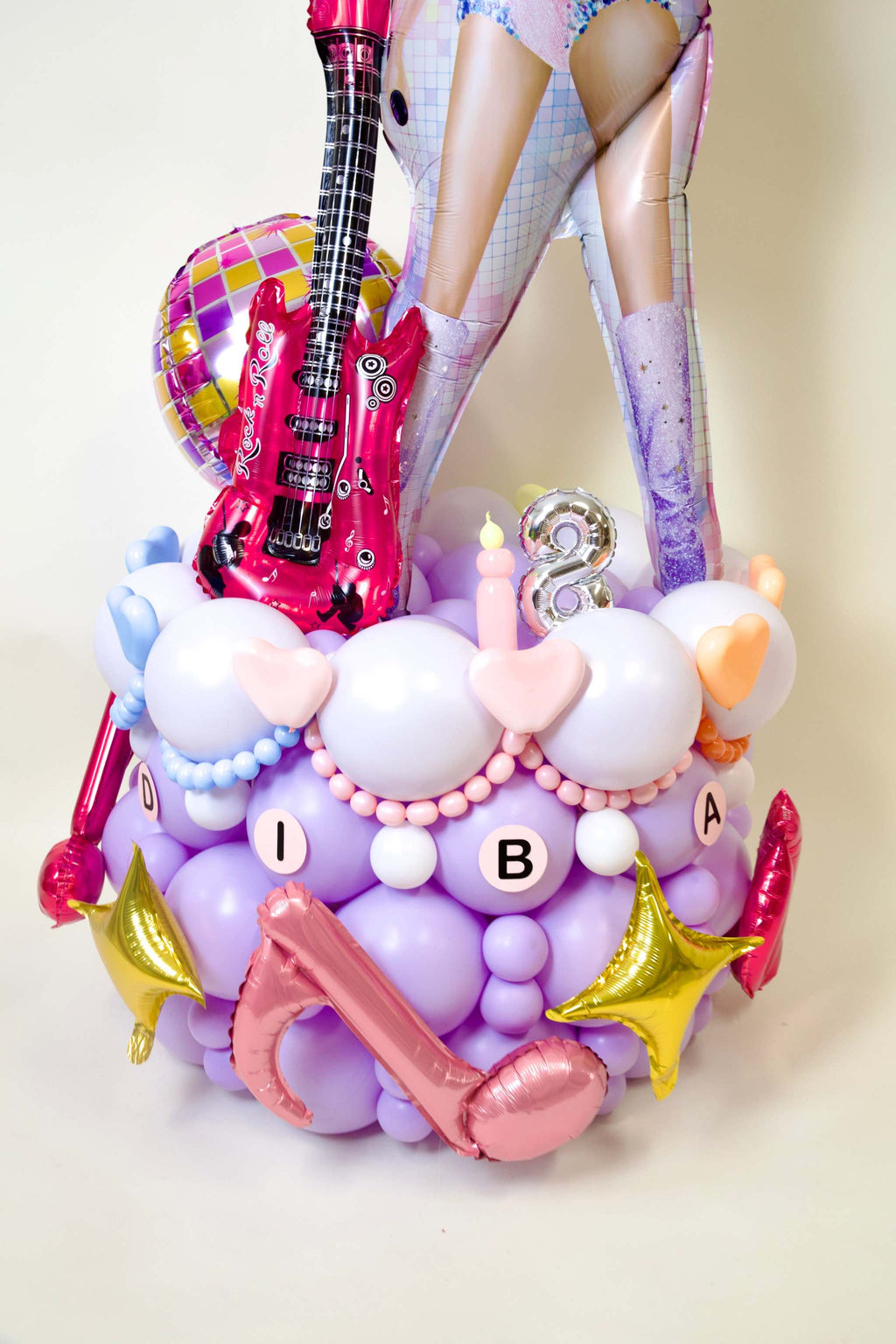 Girls Taylor Swift birthday balloon display with custom age number, guitar balloon, pastel balloon base, stars, and music party decor