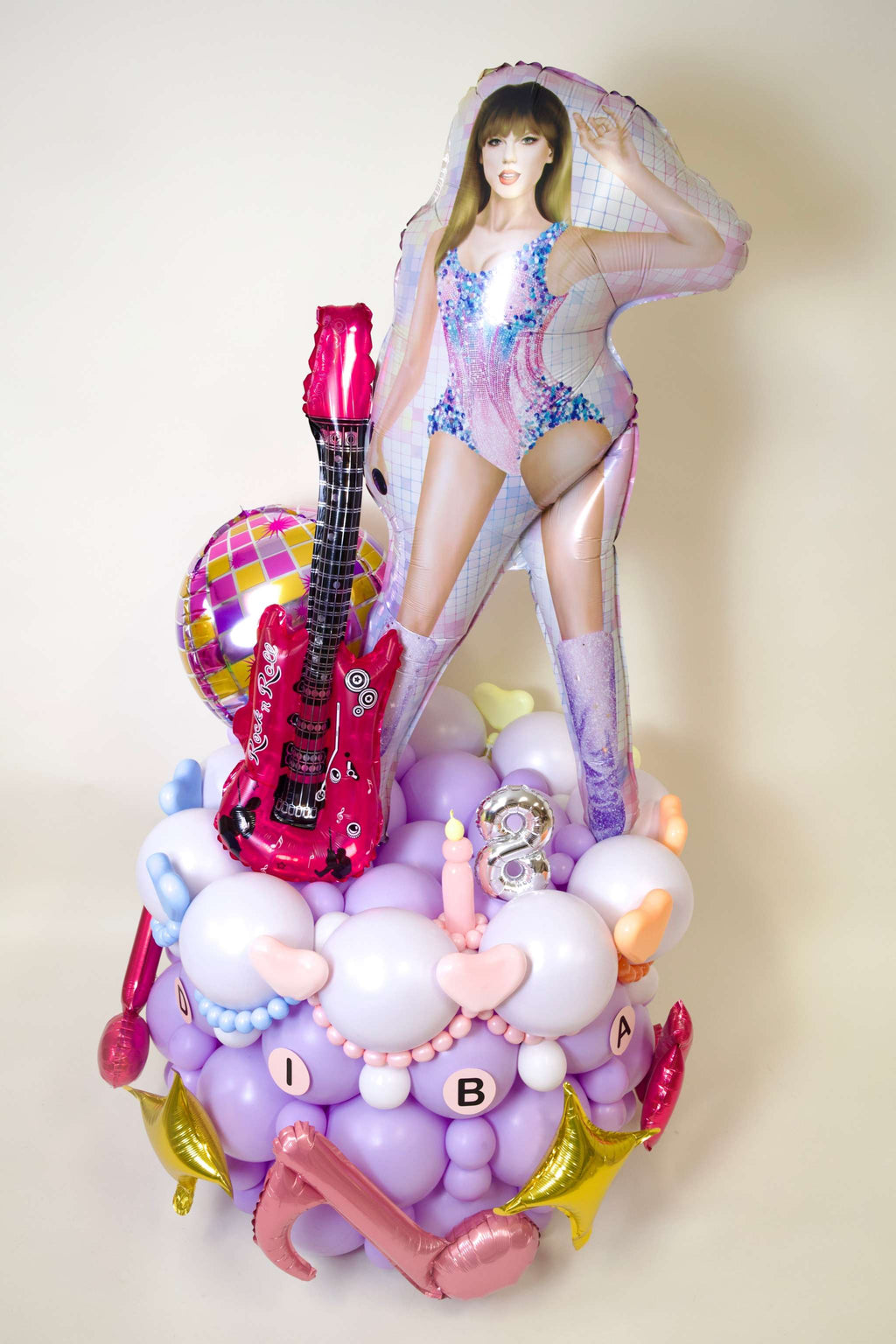 Taylor Swift Birthday Balloon Display with guitar balloon, pop star character, custom age number, pastel balloons, stars, and disco party decor