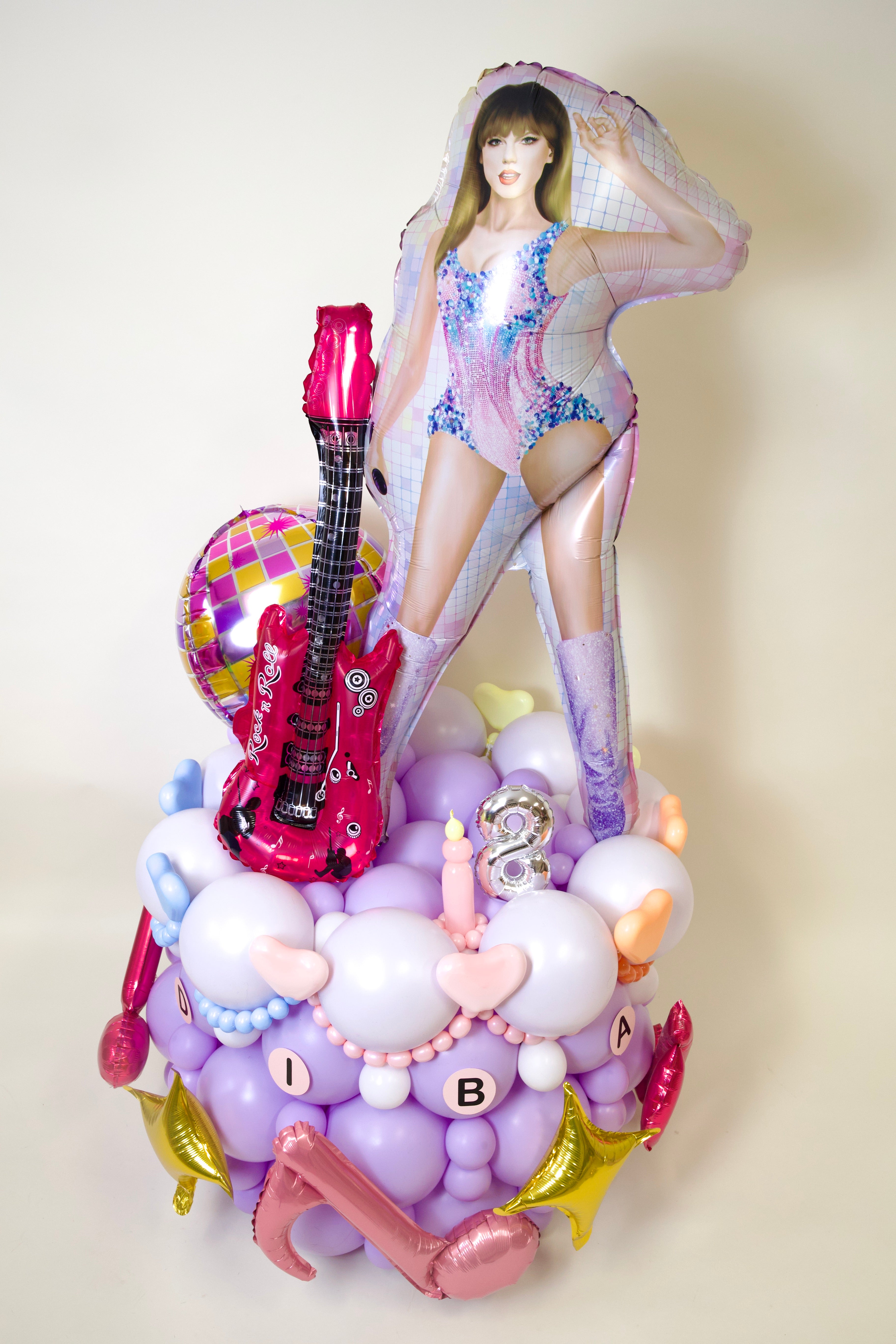 Decorative cake with a figure, guitar, and balloons on a white background