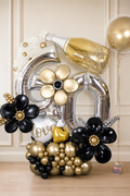 Black, gold and silver 60th birthday balloon display with champagne bottle and sculptural balloon flowers in Toronto