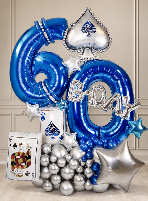 Casino Royale milestone birthday balloon display with blue and silver age numbers, playing-card accents and chrome balloon base