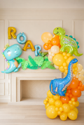 Dinosaur birthday balloon garland installation with colourful dinosaur balloons and custom name letters in Toronto