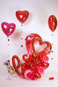 Love Balloon Arrangement with heart frame, Love script balloon, balloon roses, ring detail, and floating hearts for romantic decor in Toronto