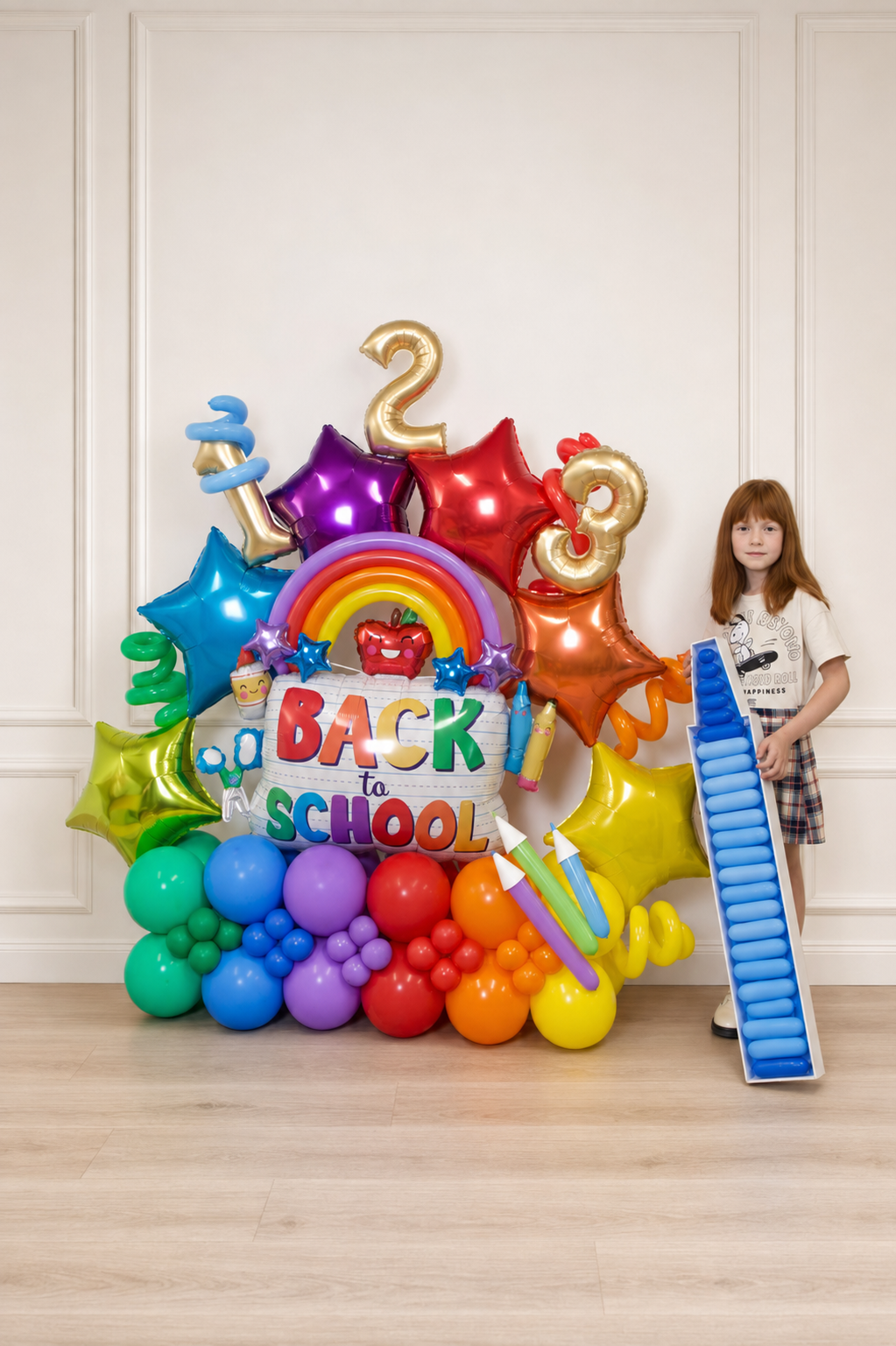 Rainbow Back to School balloon display with oversized pencil and child in Toronto