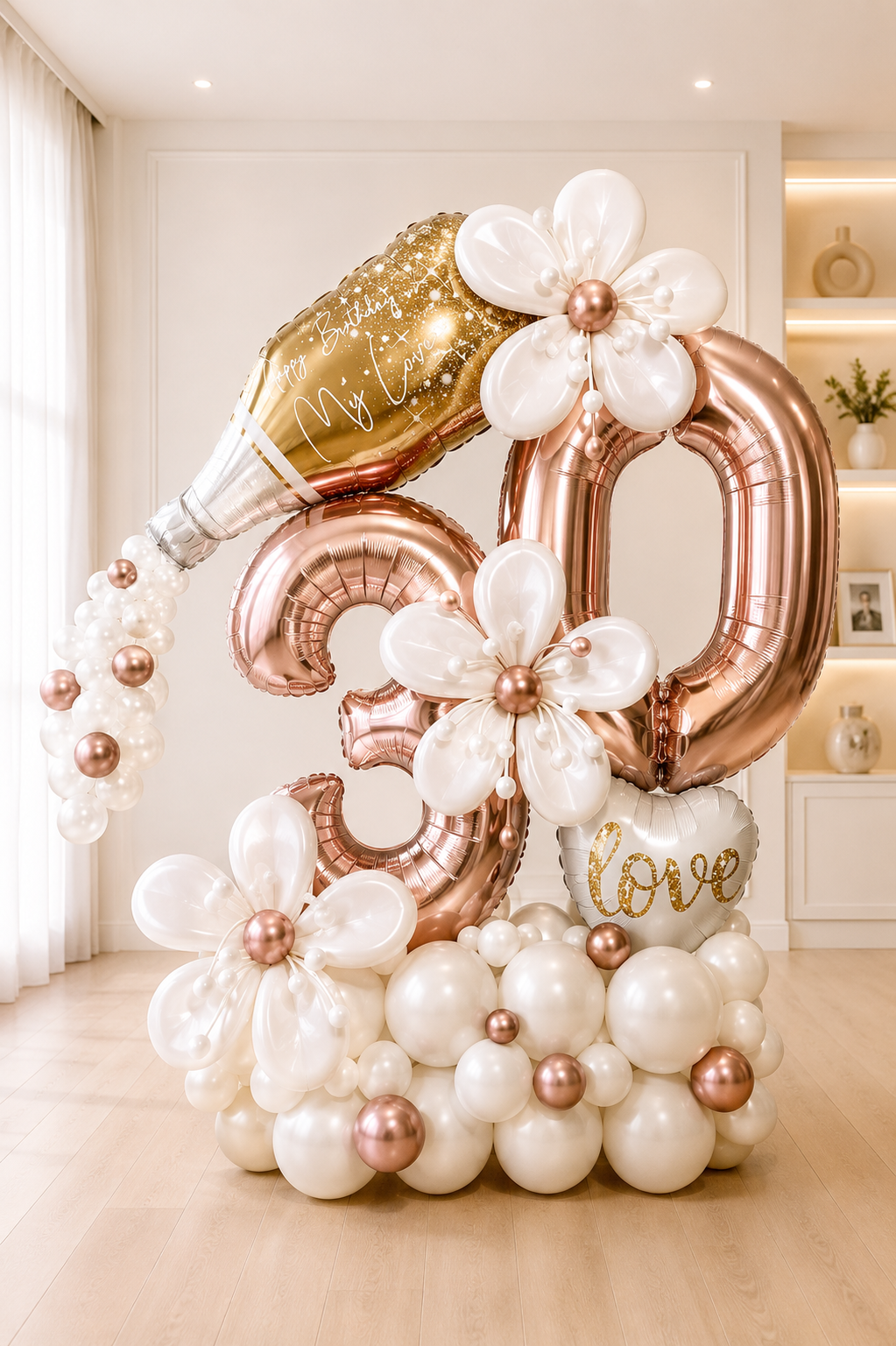 Rose gold 30th birthday balloon display with champagne bottle, pearl balloon flowers and personalized message