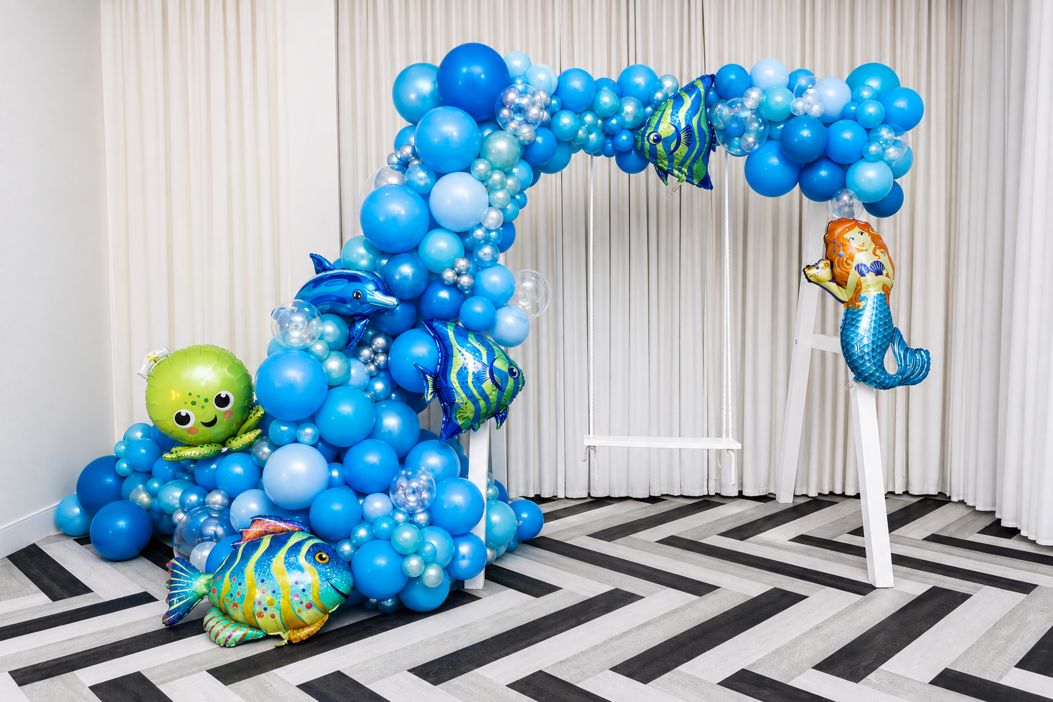 White 8 ft by 8 ft event swing styled with blue underwater balloon décor in Toronto