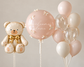 Welcome home teddy bear balloon bouquet with an ivory bear, blush statement balloon and coordinating clear and ivory balloons